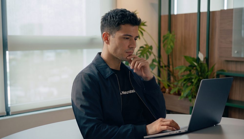 Una persona trabajando con Maverick abierto en un laptop, en una oficina de Neuratek.